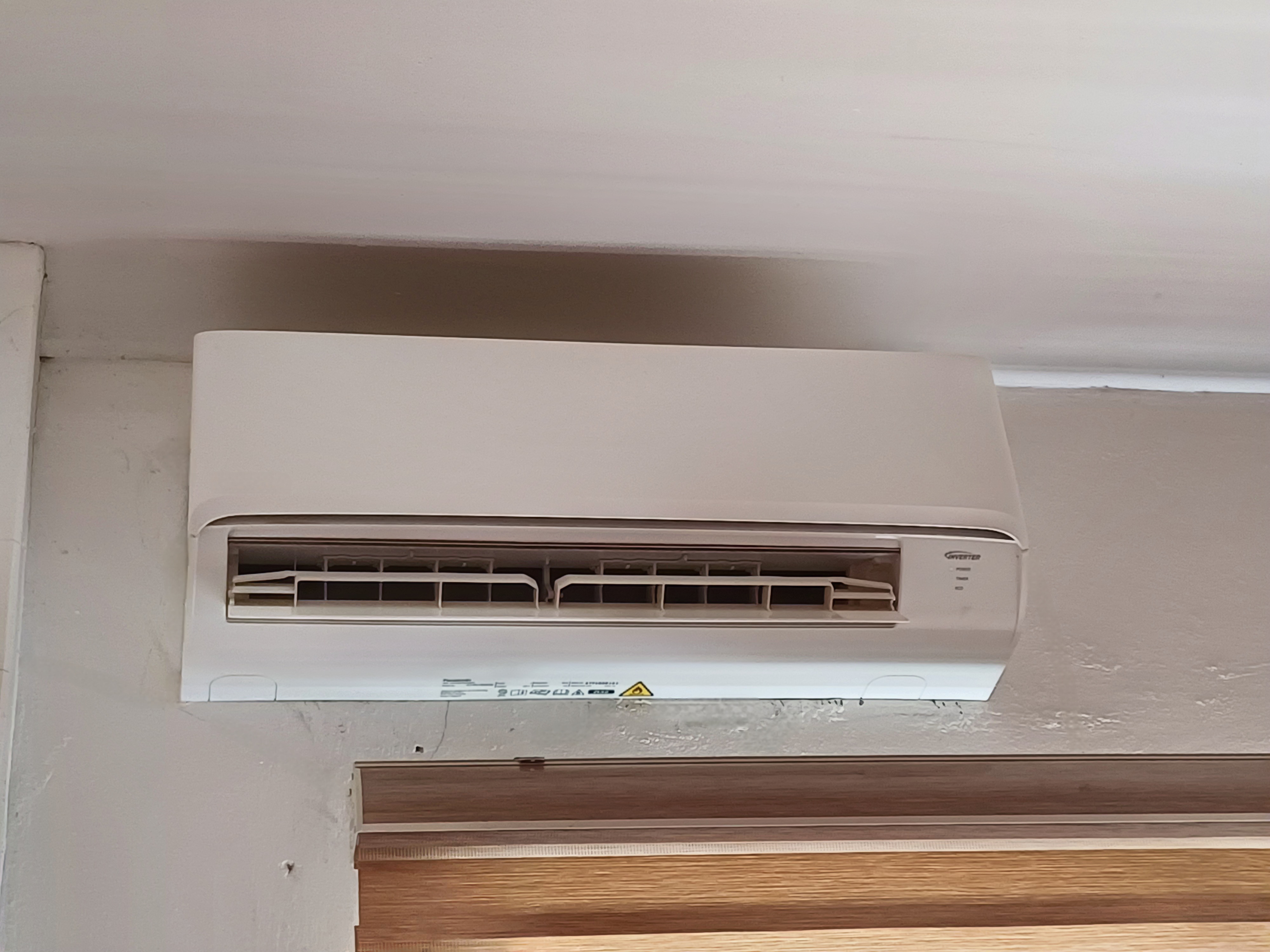 Modern wall-mounted ductless mini-split indoor head above a doorway