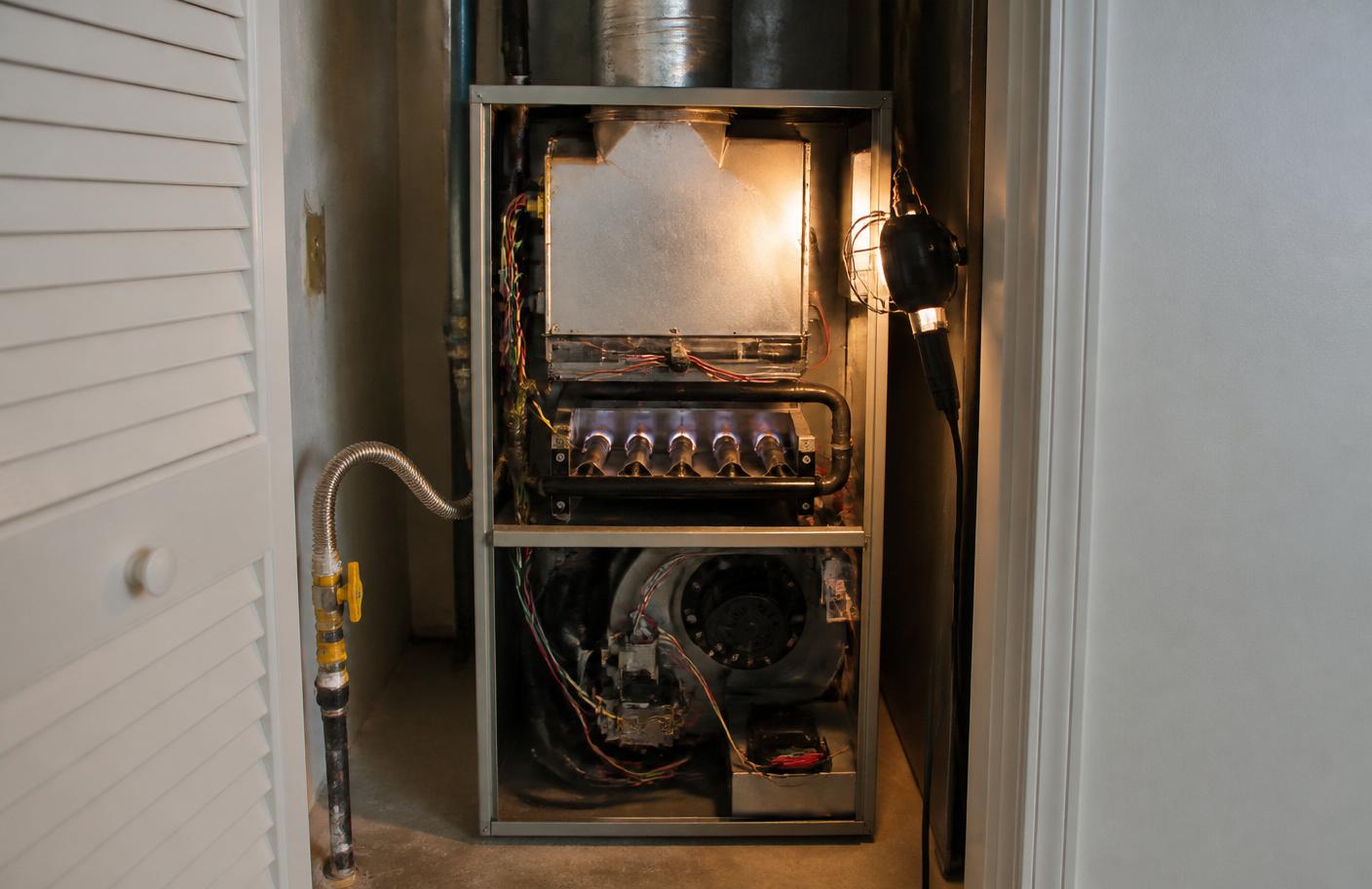 Residential gas furnace inside a home utility closet during service